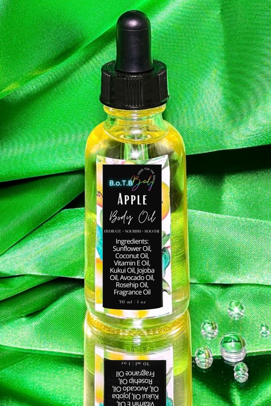 Bottle of Apple Body Oil with dropper on a green fabric background